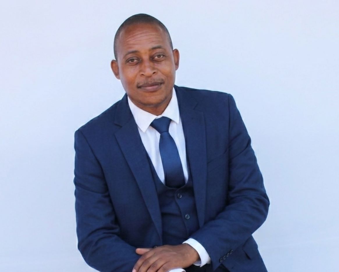 Lebo on a stool in a blue suit bust